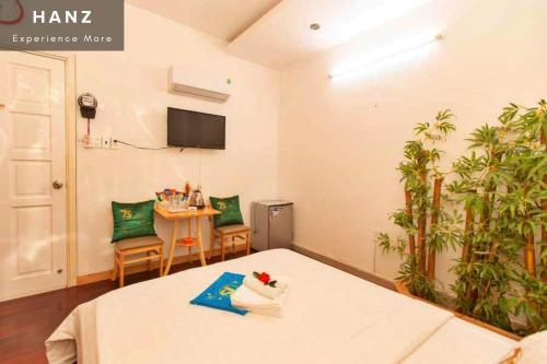 头顿HANZ Bao Khoi Hotel的配有床、桌子和电视的房间