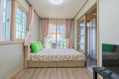 西归浦市艺术之家度假屋的一间小卧室,配有床和窗户
