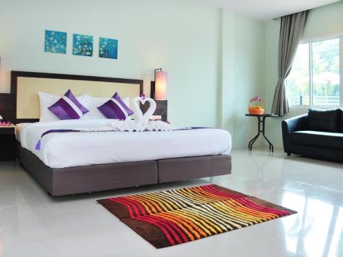 苏林海滩AM Surin Place - SHA Extra Plus的一间卧室配有一张大床和一张沙发
