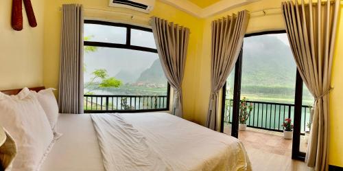峰牙Phong Nha Coco Riverside的一间卧室设有一张床和一个大窗户