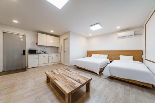 束草市Seorak HOT Spring Mammoth Resotel的一间卧室配有两张床和一张桌子