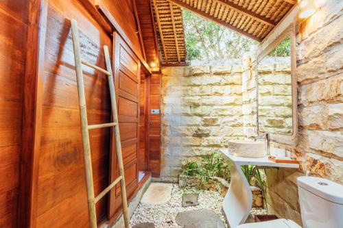 珀尼达岛Bila Penida Resort & Farm的一间带卫生间和石墙的浴室