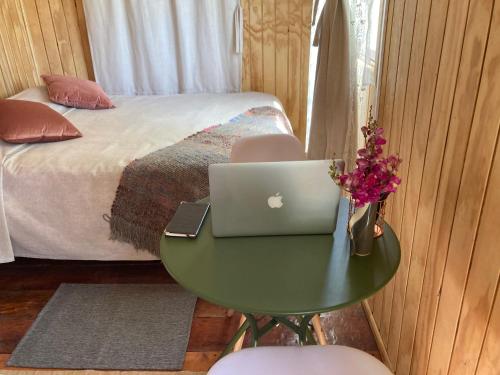 奇廉Cabaña Lemupewen Chillán的一间卧室,床边的桌子上放着一台笔记本电脑