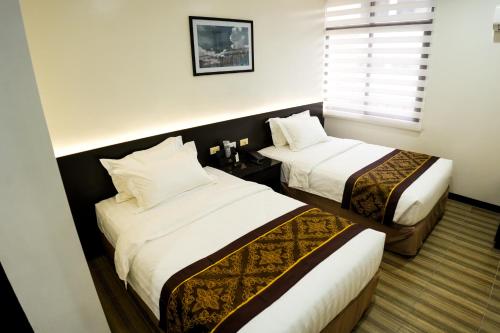 卡加盐德奥罗PRIMELUXE HOTEL的酒店客房设有两张床和窗户。