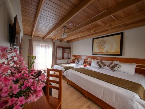 奥兰太坦波Sol Ollantay Exclusive Hotel的酒店客房带两张床和花瓶