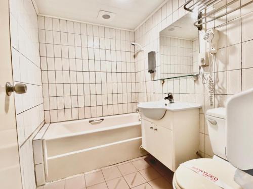 新竹WL HOTEL Hsinchu的浴室配有卫生间、浴缸和水槽。