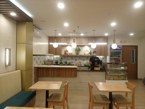 卡加盐德奥罗PRIMELUXE HOTEL的一间带两张木桌和厨房的餐厅