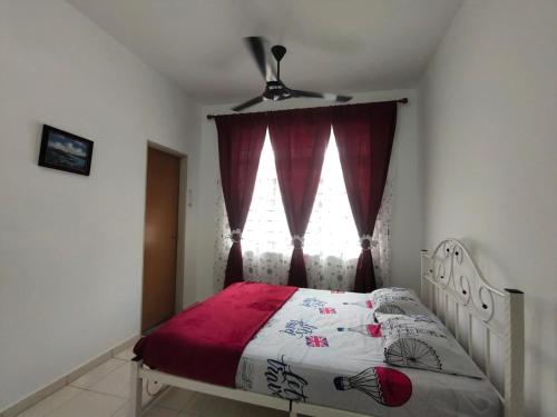Rantau PanjangHOMESTAY HAIKALHAIDAR的一间卧室配有一张带红色窗帘的床和窗户