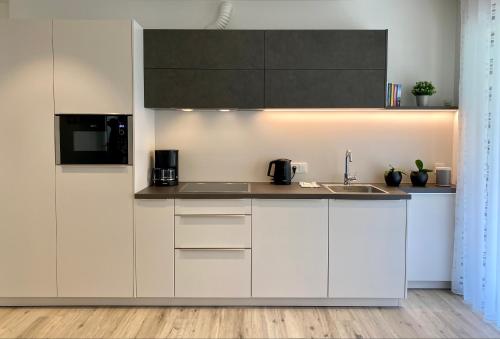 梅拉诺Neu, zentral, sonnig, Garage inklusive的厨房配有白色橱柜和水槽