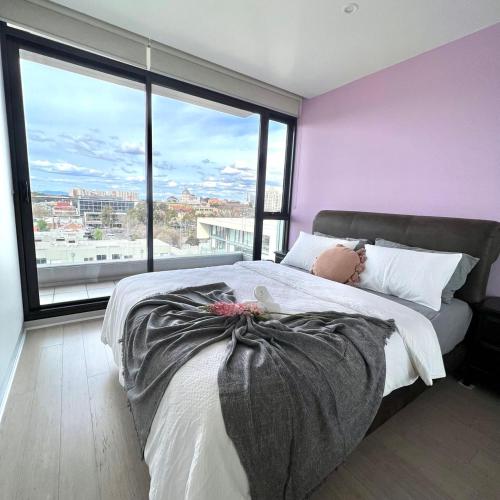 墨尔本Carlton Stunning View Apartment 150m away from University of Melbourne的一间卧室配有一张大床和紫色墙壁