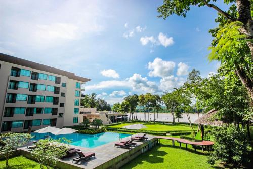 清刊River Tree Resort的享有酒店的景致,设有游泳池和躺椅