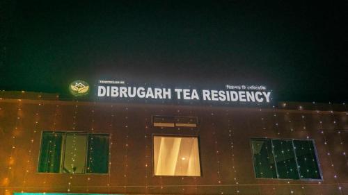 迪布鲁加尔Dibrugarh Tea Residency的上面有标志的建筑