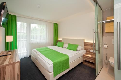 韦尔特湖畔克伦彭多夫Happy Lake by Thomas Strugger的一间卧室配有一张绿色的大床