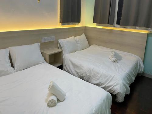 山打根Sandakan Homestay SEMi D 3R2B For 10Pax的两张位于酒店客房的床,配有毛巾