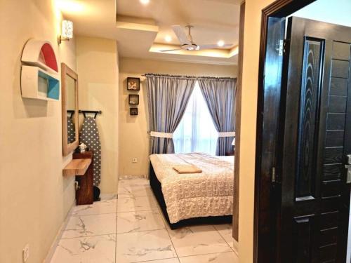 拉瓦尔品第Comfortable & Lovely 1 Bed Apt In Bahria Town的一间小卧室,配有床和窗户