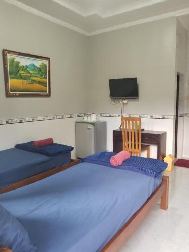 库塔捷鹏塞加拉旅馆的一间卧室设有两张床、一台电视和一把椅子
