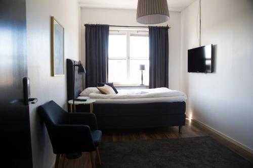 埃克舍Eksjö Longstay的一间卧室配有一张床和一个带椅子的窗户
