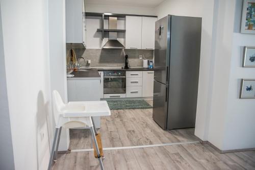 比托拉L&L Luxury Apartments的厨房配有不锈钢冰箱和桌子