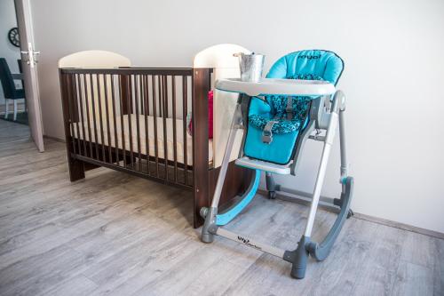 比托拉L&L Luxury Apartments的一张蓝色高脚椅,紧靠着婴儿床