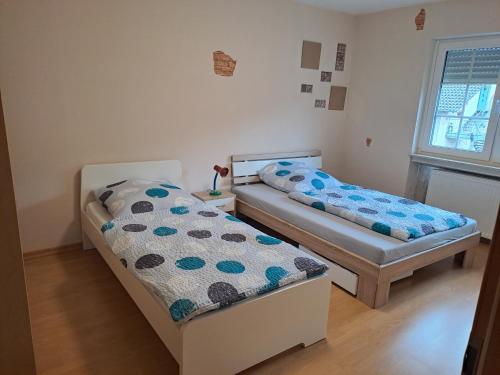 皮特林根Ferienwohnung Schleiten的小型客房 - 带2张床和窗户