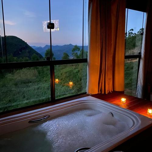 圣特雷莎Chalé Milão Caravaggio的浴缸位于享有美景的窗户前