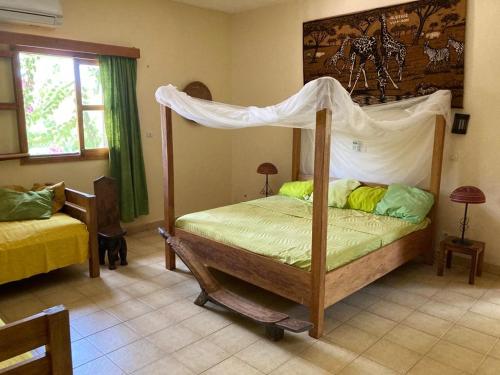 博博迪乌拉Villa Rose的一间卧室配有一张带天蓬的床