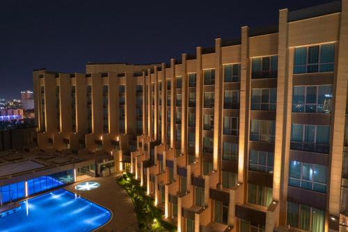 巴士拉Grand Millennium Al Seef Basra的一座晚上设有游泳池的建筑