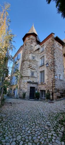 勒布伊Maison au Loup - Superbe ancien hotel particulier du XVIe siècle au cœur de la vieille ville du Puy的街道上一座大型石头建筑,塔楼