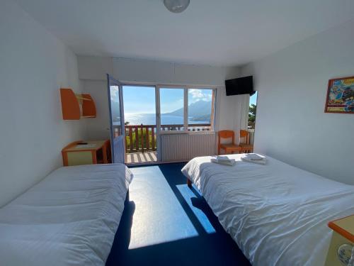 泰晤勒·苏尔·梅尔Village Vacances Lou Castelet的带阳台的客房内的两张床