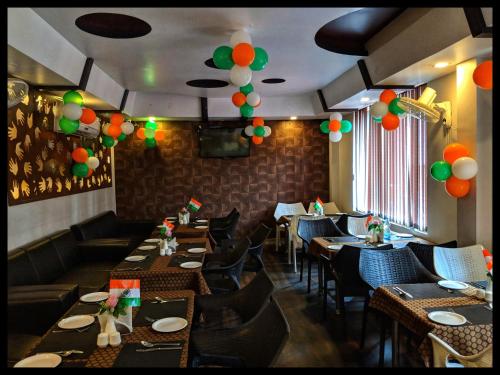 RourkelaTHE PRESTIGE HOTEL & CONVENTION的餐厅设有桌椅和天花板上的气球