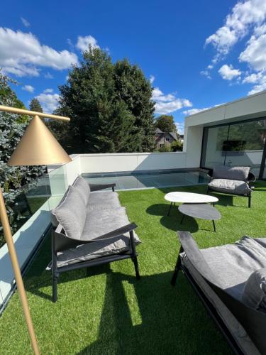 那慕尔Comme chez Lore - villa 2pers - piscine chauffée的庭院配有桌椅和草地。