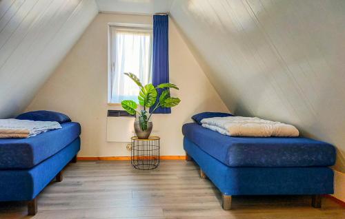 GramsbergenVijverzicht 218 met whirlpool的带窗户的客房内的2张蓝色的床