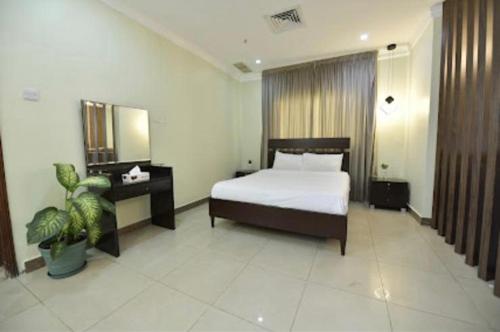 科威特诺贝洛斯公寓式酒店的酒店客房,配有床和镜子