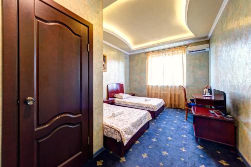 基辅Hotel Kiev Lomakin的一间酒店客房,设有两张床和一扇门