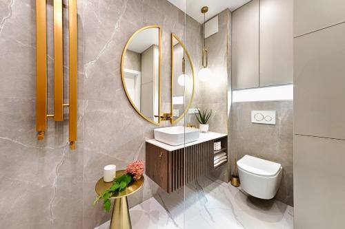 罗兹Wyjątkowy Taupe Apartament w centrum Łodzi的一间带水槽和镜子的浴室