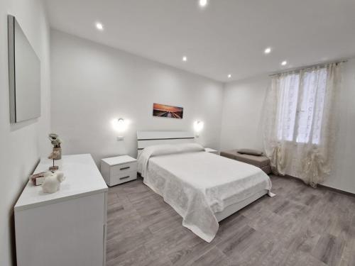 塔兰托La casa di Teresa的一间白色卧室,配有一张床和两张桌子