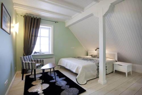珀尔沃卡Vila Pervalka的一间卧室配有一张床、一张桌子和一个窗户。