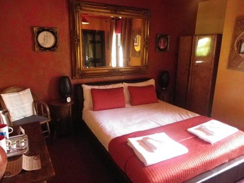 威根斯文里法夫特斯宾馆的一间卧室配有一张带红色墙壁和镜子的床
