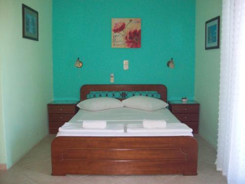 阿索斯GARY APARTMENTS的一间卧室配有一张带蓝色墙壁的大床