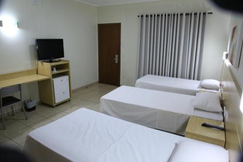 AndradinaSavana Park Hotel的酒店客房设有两张床和电视。