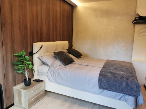 利塔尼EHINACEA的卧室配有白色的床和盆栽植物