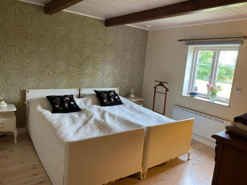 GlemmingeDrömhus på Österlen的卧室配有带黑色枕头的白色床