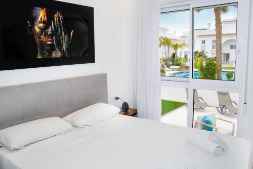 克萨达城Premium Ferienwohnung: Allegra - Alba - Residential的卧室设有白色的床和大窗户