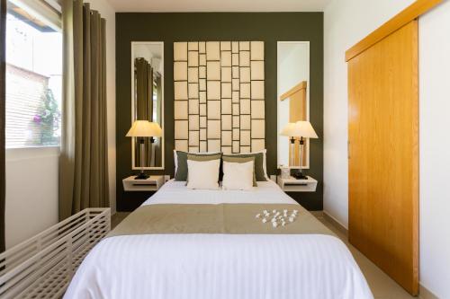 瓦哈卡市ArcoSodi Hotel Boutique的一间卧室配有一张大床和两盏灯。
