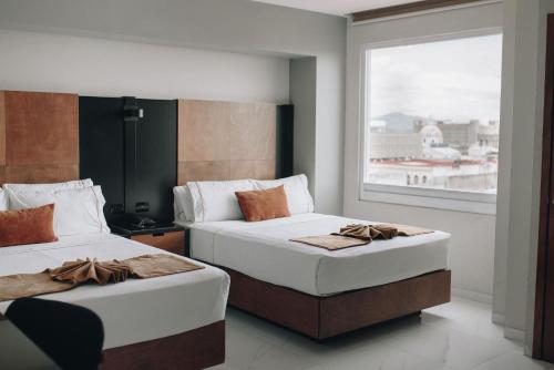 瓜达拉哈拉大理广场艾街库提夫酒店的带窗户的客房内的两张床