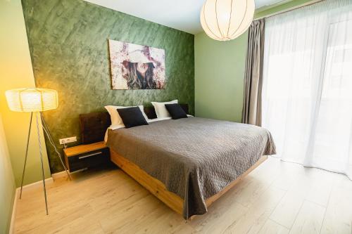 锡比乌Alice apartment的一间卧室设有一张床和绿色的墙壁