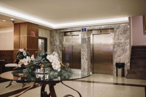 瓜达拉哈拉大理广场艾街库提夫酒店的大堂设有两部电梯和一张鲜花桌。