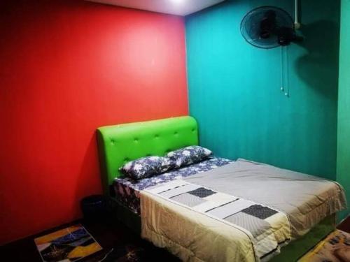 大港Chalet kolam renang D'sawah的一间设有一张绿色和红色墙壁的床的房间