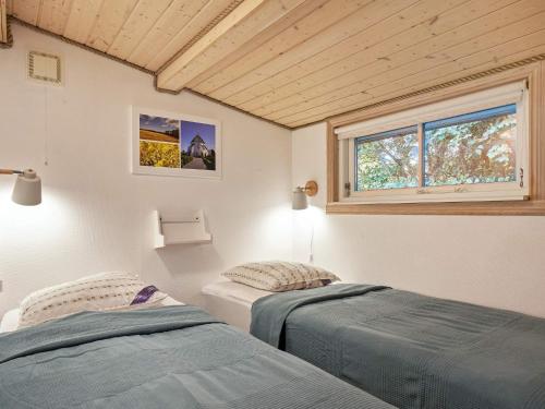 内克瑟Holiday home Nexø XLI的带窗户的客房内的两张床
