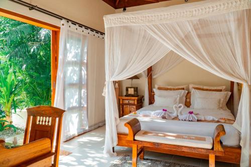 塞米亚克Villa Dayak的一间卧室设有天蓬床和窗户。